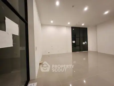 Spacious empty room with large windows and tiled flooring, ideal for customization.