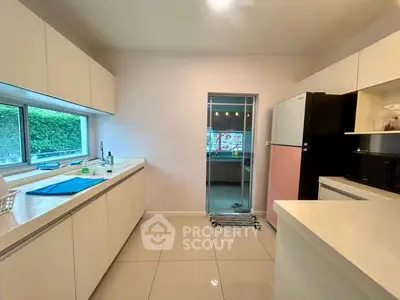 Modern kitchen with sleek white cabinets and large window view