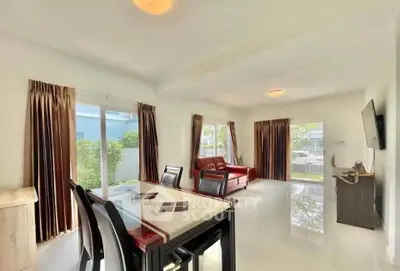 Spacious living room with modern dining set and large windows for natural light.
