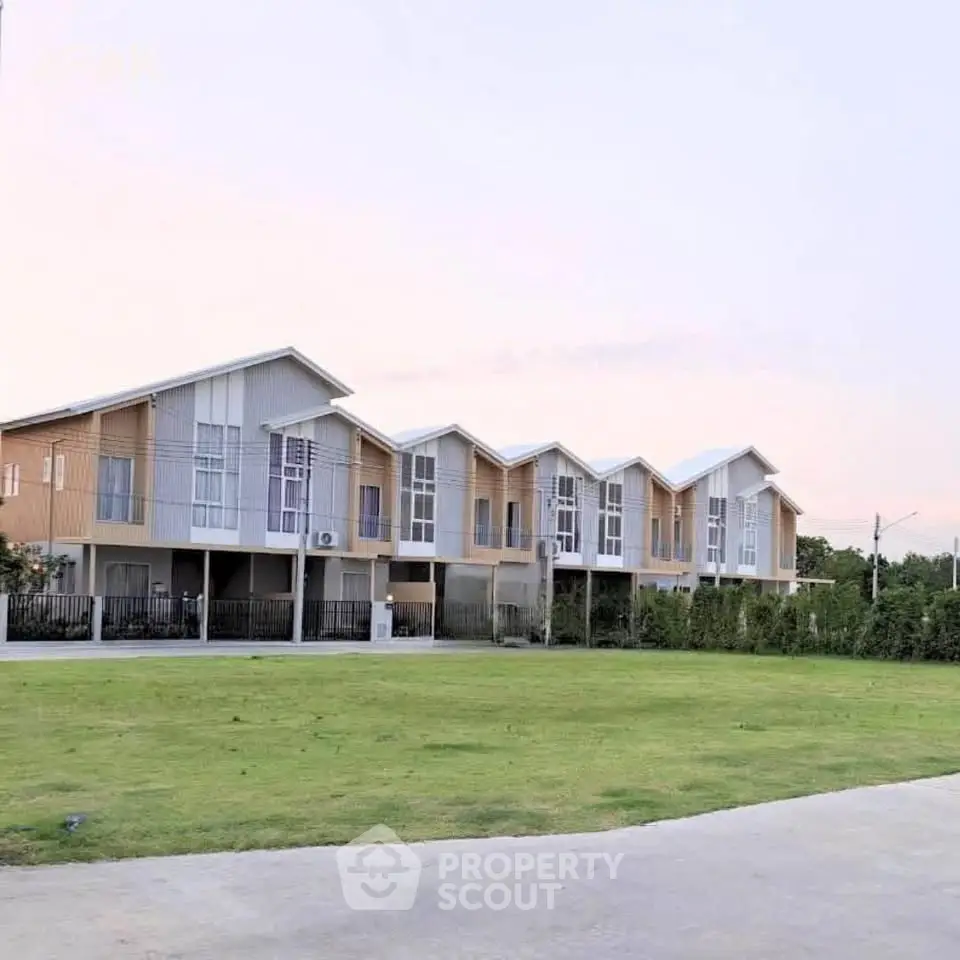 Modern townhouse complex with spacious green lawn and contemporary design.