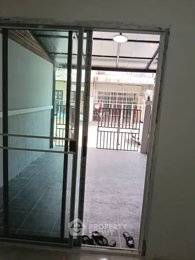 Spacious patio with sliding glass doors leading to a tiled outdoor area, perfect for relaxation.