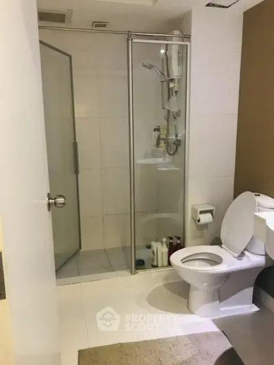 Modern bathroom with glass shower and white fixtures in a contemporary home.