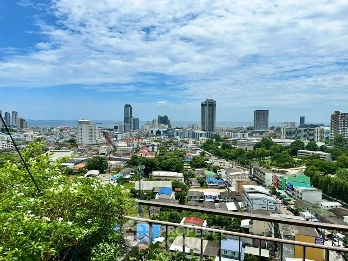 Stunning cityscape view from a high-rise balcony with lush greenery.
