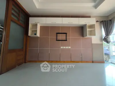 Spacious living room with modern wall unit and large windows