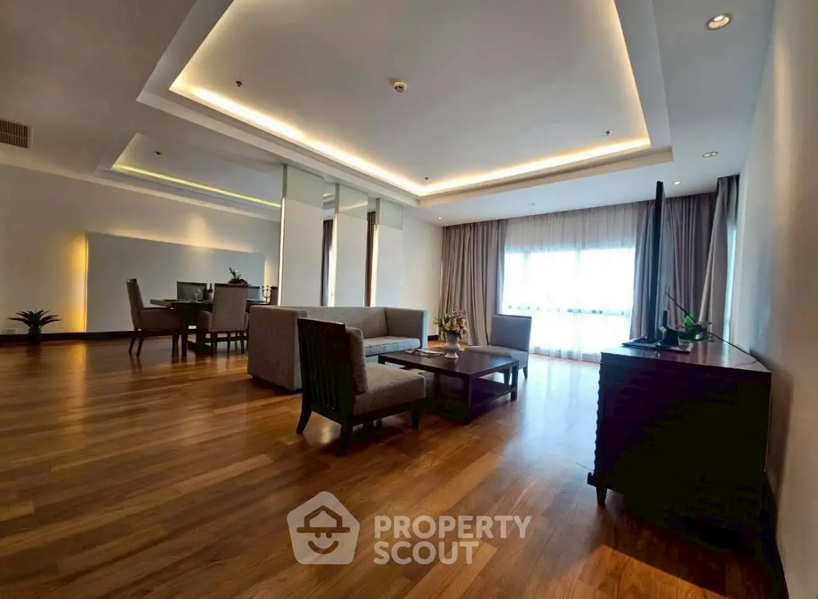 Spacious modern living room with elegant wooden flooring and stylish furniture, perfect for luxury living.