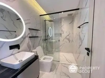 Luxurious modern bathroom with marble walls and glass shower enclosure