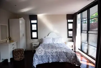 Spacious bedroom with large windows and elegant decor