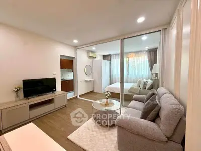 Modern open-plan living room with cozy sofa and stylish decor in a bright apartment.