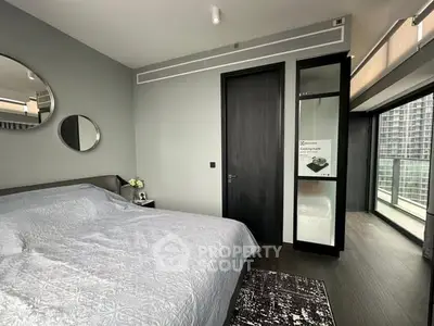 Modern bedroom with balcony access and stylish decor in urban apartment.
