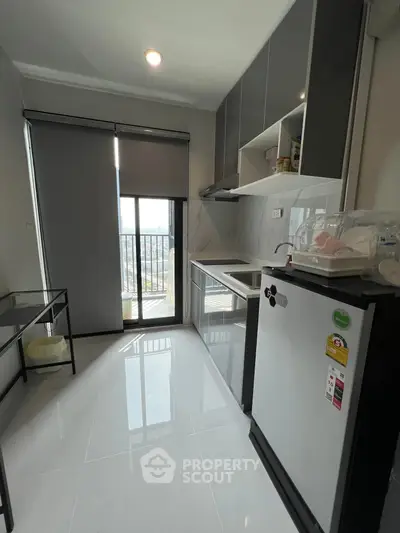 Modern kitchen with sleek cabinets and balcony view