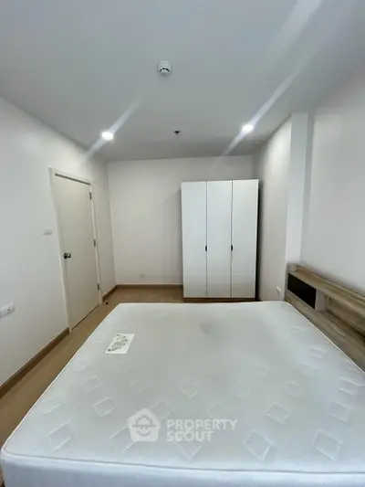 Spacious bedroom with modern wardrobe and comfortable bed in a stylish apartment.