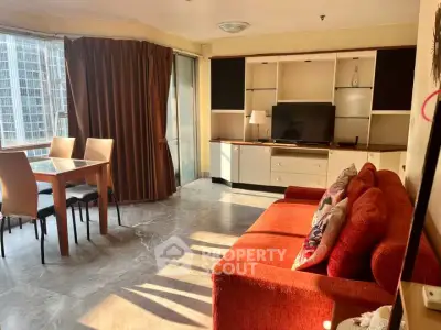 Spacious living room with modern furniture and large windows offering city views.