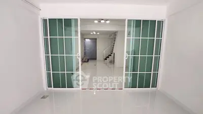 Spacious modern interior with sliding glass doors and sleek staircase, perfect for contemporary living.