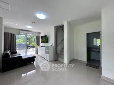 Spacious modern living room with sleek design and large windows offering natural light and garden view.