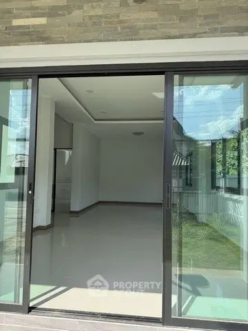 Spacious modern living room with large sliding glass doors opening to a garden view, perfect for natural light.