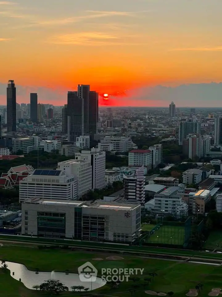 Stunning cityscape view at sunset with high-rise buildings and lush green golf course.