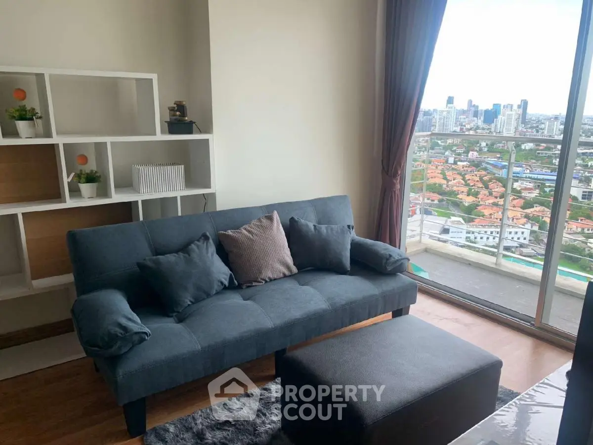 Modern living room with city view from balcony, stylish sofa and shelving unit.