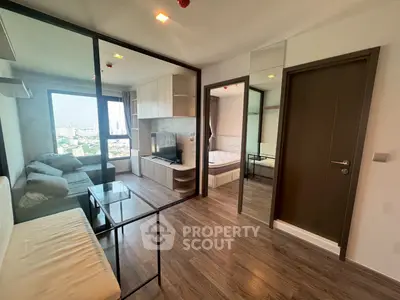 Modern apartment with glass partition, cozy living area, and city view.