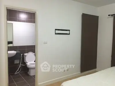 Modern bedroom with ensuite bathroom featuring sleek design and neutral tones.