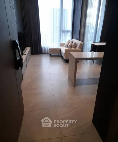 Modern living room with large windows and stylish furniture in a high-rise apartment.