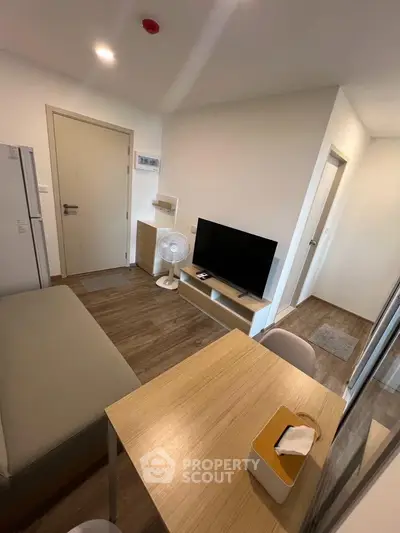 Modern compact living room with TV and dining area in cozy apartment