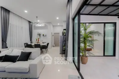 Modern open-plan living room with elegant decor and sliding glass doors