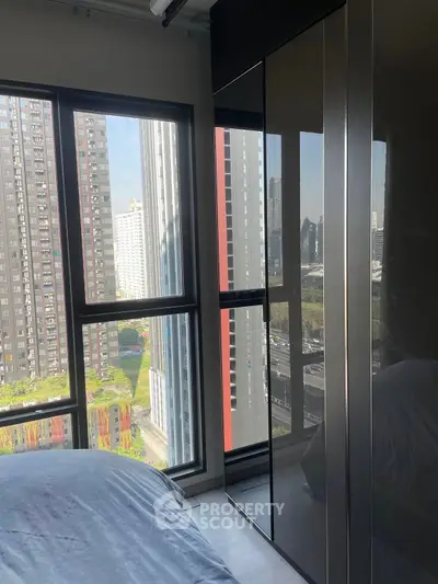 Modern bedroom with city view and sleek wardrobe in high-rise apartment