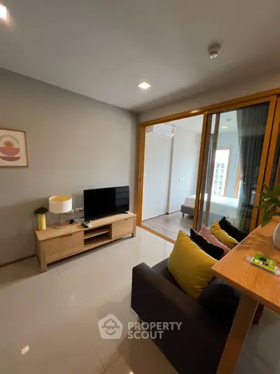 Modern living room with sleek design and cozy atmosphere, featuring a TV and stylish furniture.
