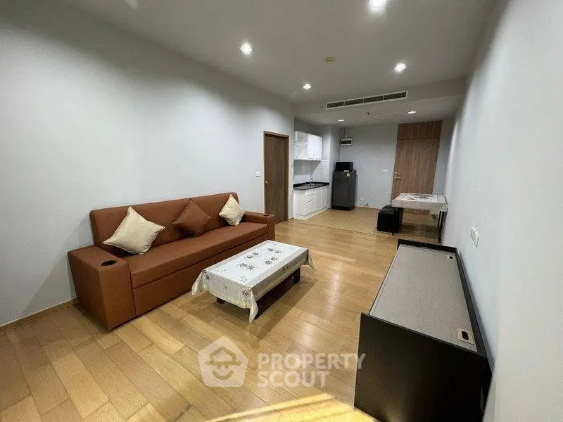 Spacious modern living room with wooden flooring and cozy furniture in a stylish apartment.