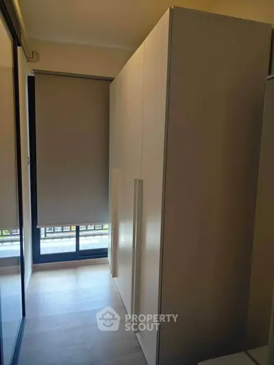 Modern storage space with sleek cabinetry and natural light from large window.