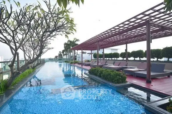 Luxurious rooftop pool with stylish pergola and lush greenery, perfect for relaxation and leisure.