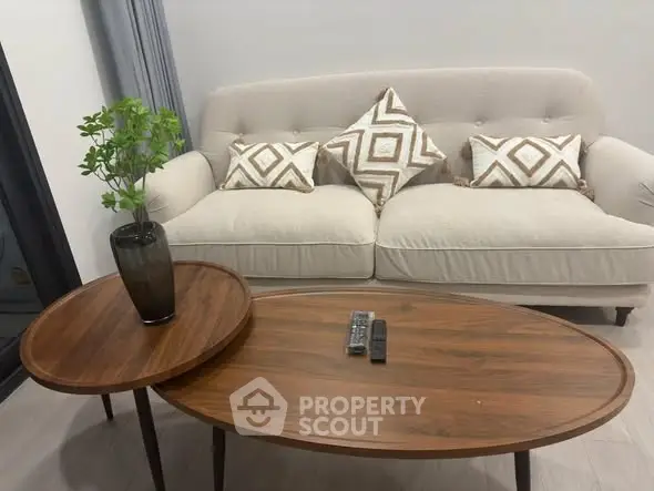 Stylish living room with modern sofa and elegant wooden coffee tables, perfect for cozy gatherings.
