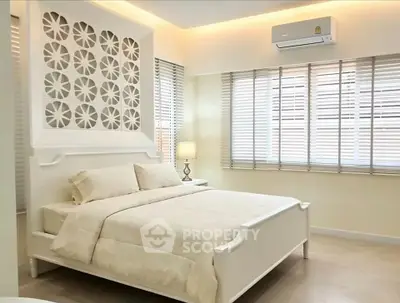 Elegant bedroom with modern decor and ample natural light from large windows.