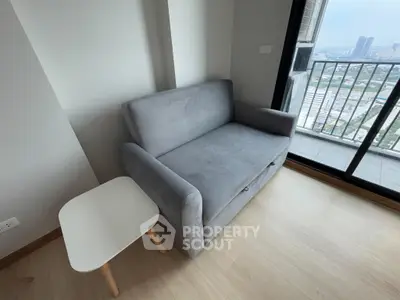 Cozy living room with a gray sofa and balcony view