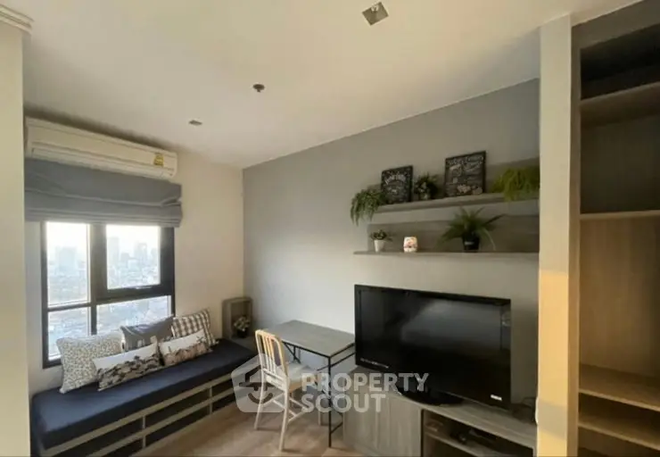 Cozy living room with city view, featuring a TV, desk, and stylish decor.