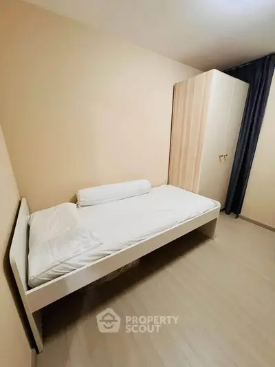 Minimalist bedroom with single bed and wardrobe, perfect for cozy living.