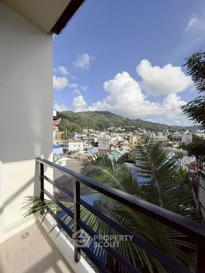 Stunning balcony view overlooking vibrant cityscape and lush hills, perfect for urban living.