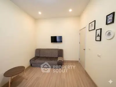 Cozy living room with modern sofa and wall-mounted TV, perfect for relaxation.