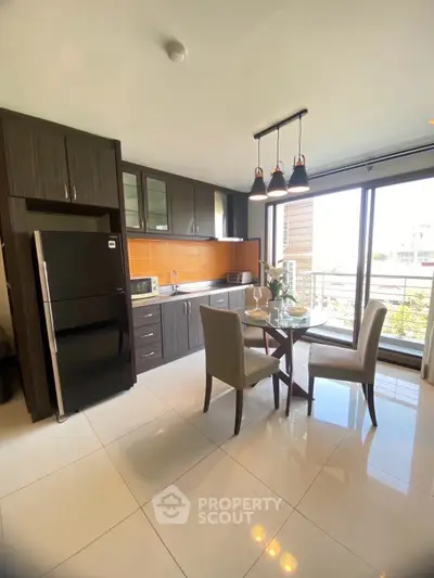 Modern kitchen with dining area and large windows offering natural light