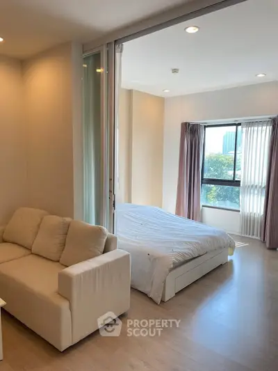 Modern studio apartment with cozy living area and bright bedroom