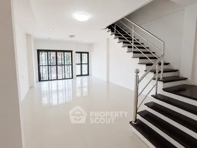 Spacious modern living room with sleek staircase and large windows