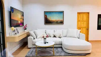 Stylish living room with modern sofa, wall art, and mounted TV in a cozy setting.