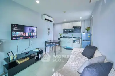 Modern living room with open kitchen, sleek decor, and wall-mounted TV in a stylish apartment.