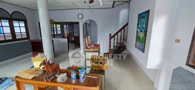 Spacious living room with staircase and large windows in a modern home.