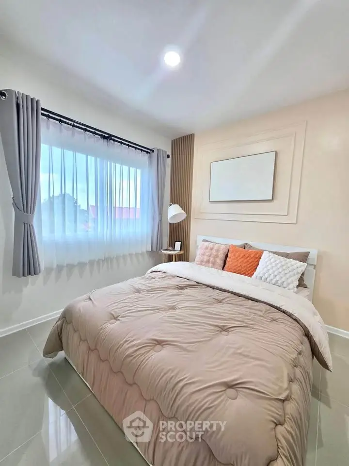 Cozy bedroom with elegant decor and ample natural light, featuring a stylish bed and modern furnishings.