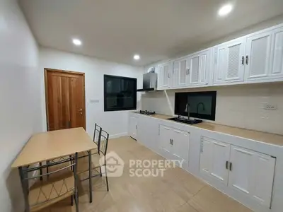 Modern kitchen with sleek cabinets and dining area