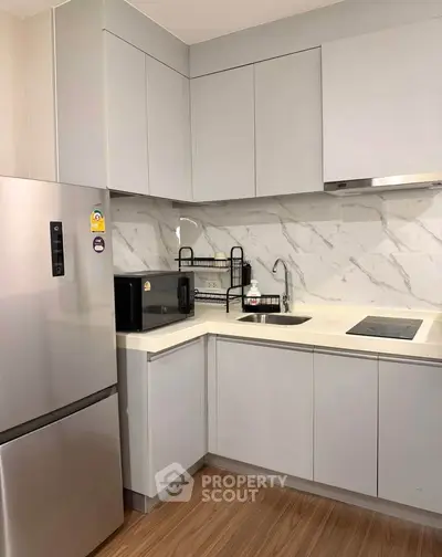 Modern kitchen with sleek cabinetry and stainless steel appliances in a compact layout.