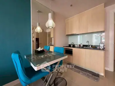 Modern kitchen with sleek cabinetry and stylish dining area in a contemporary apartment.