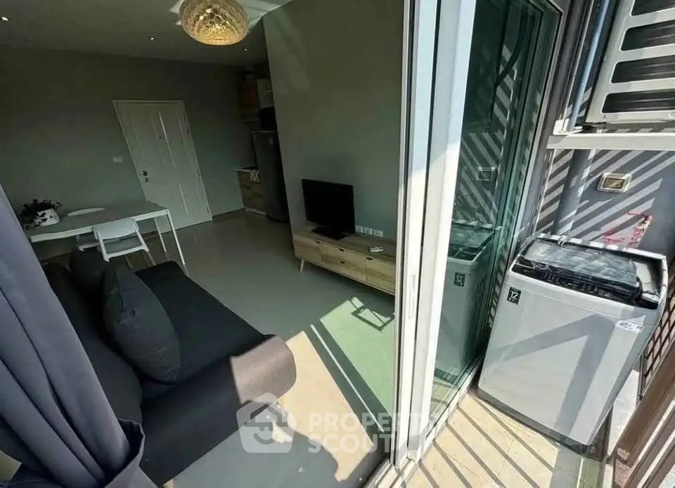 Modern apartment with open living area and balcony featuring washing machine.