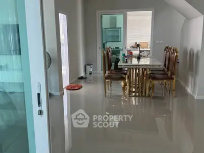 Elegant dining room with glossy floors and luxurious gold-accented table set